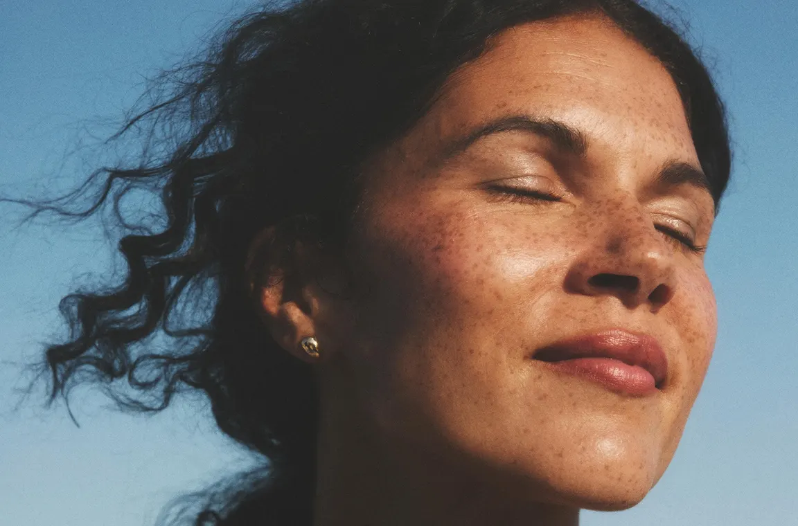 Woman with sun on her face looking calm