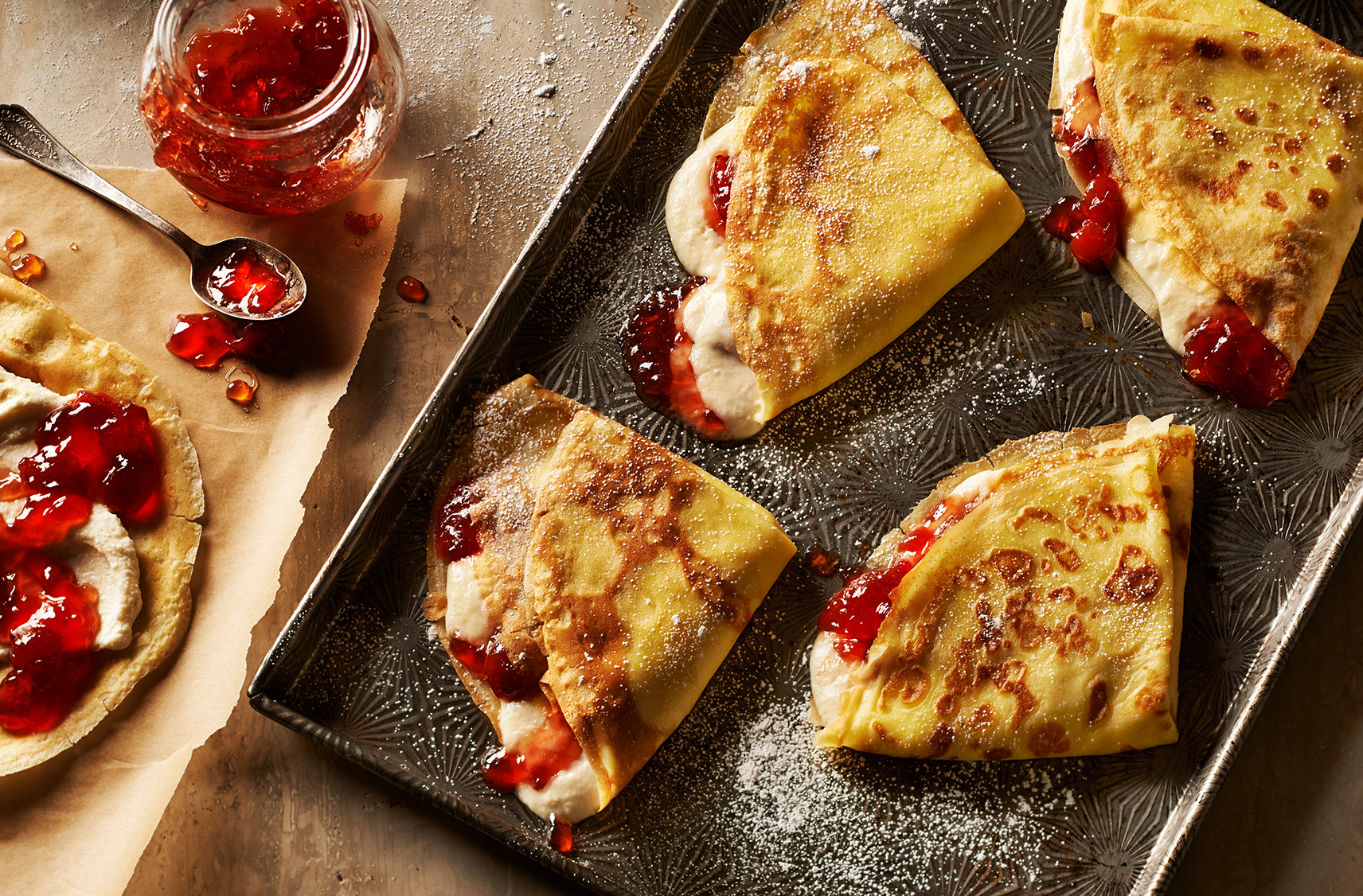 Fluffy golden crepes stuffed with creamy mascarpone and cherry spread