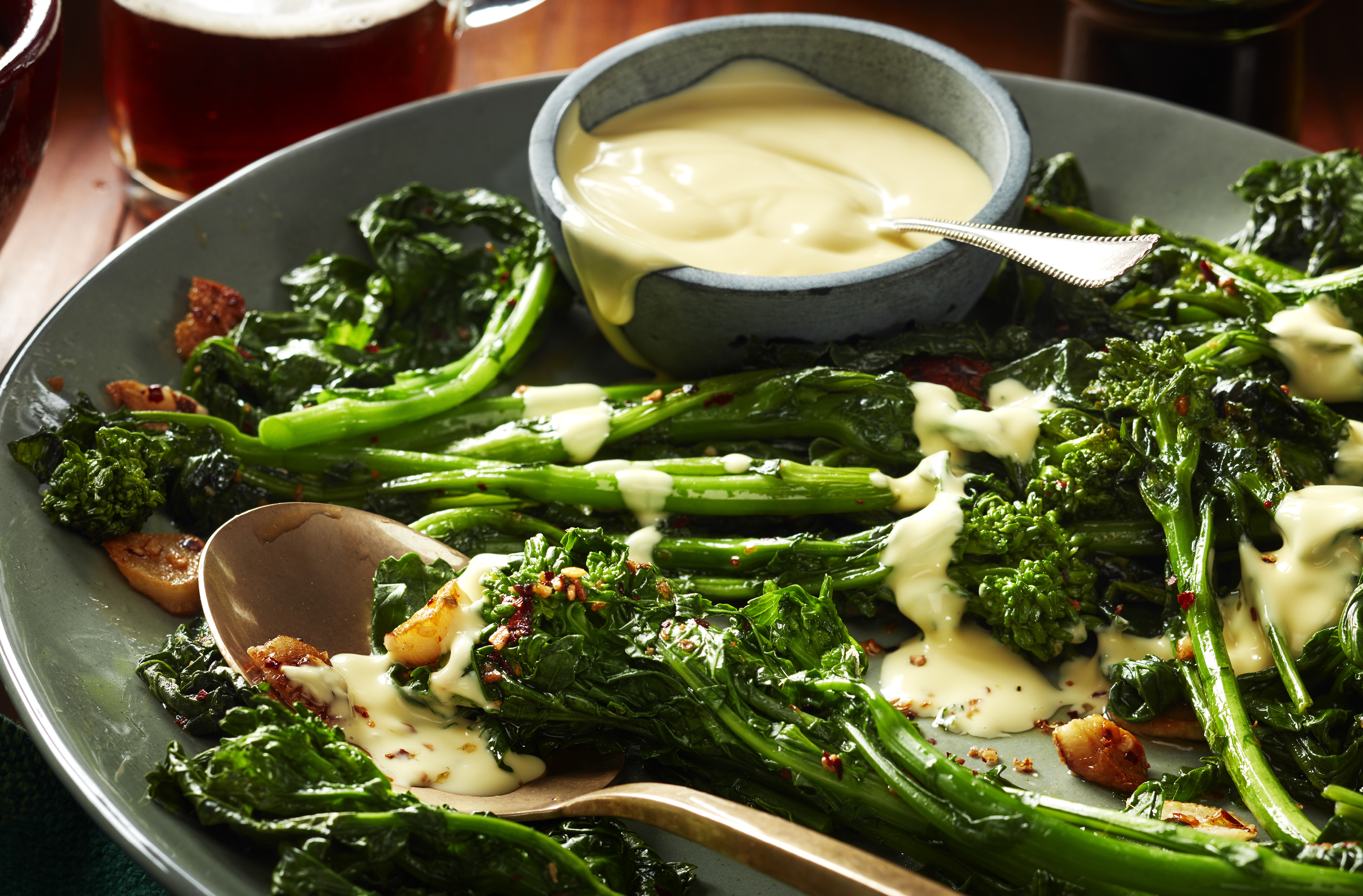 A platter of spiced rapini drizzled with hollandaise sauce 
