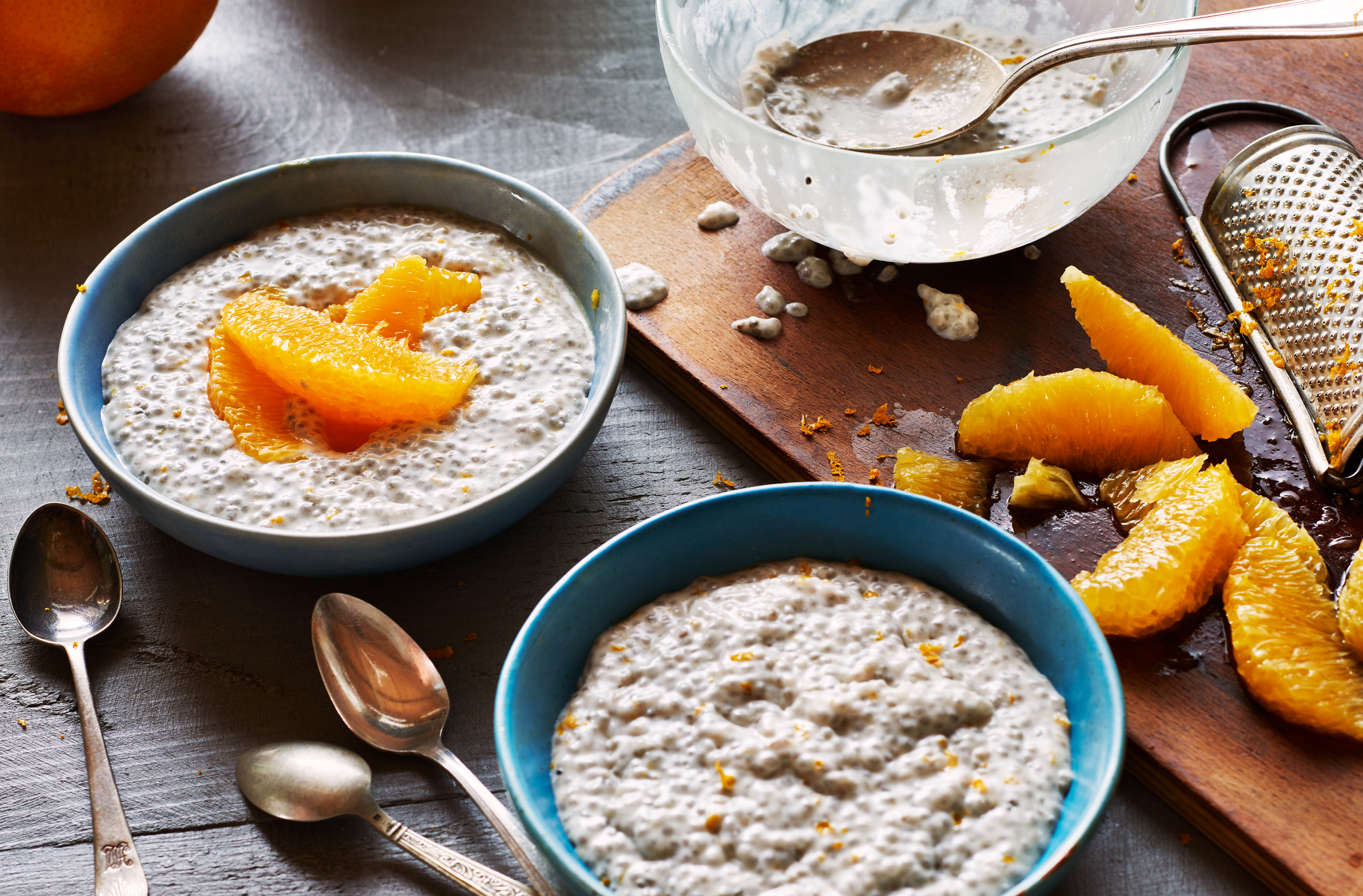 Two bowls of orange creamsicle chia pudding, one topped with orange slices
