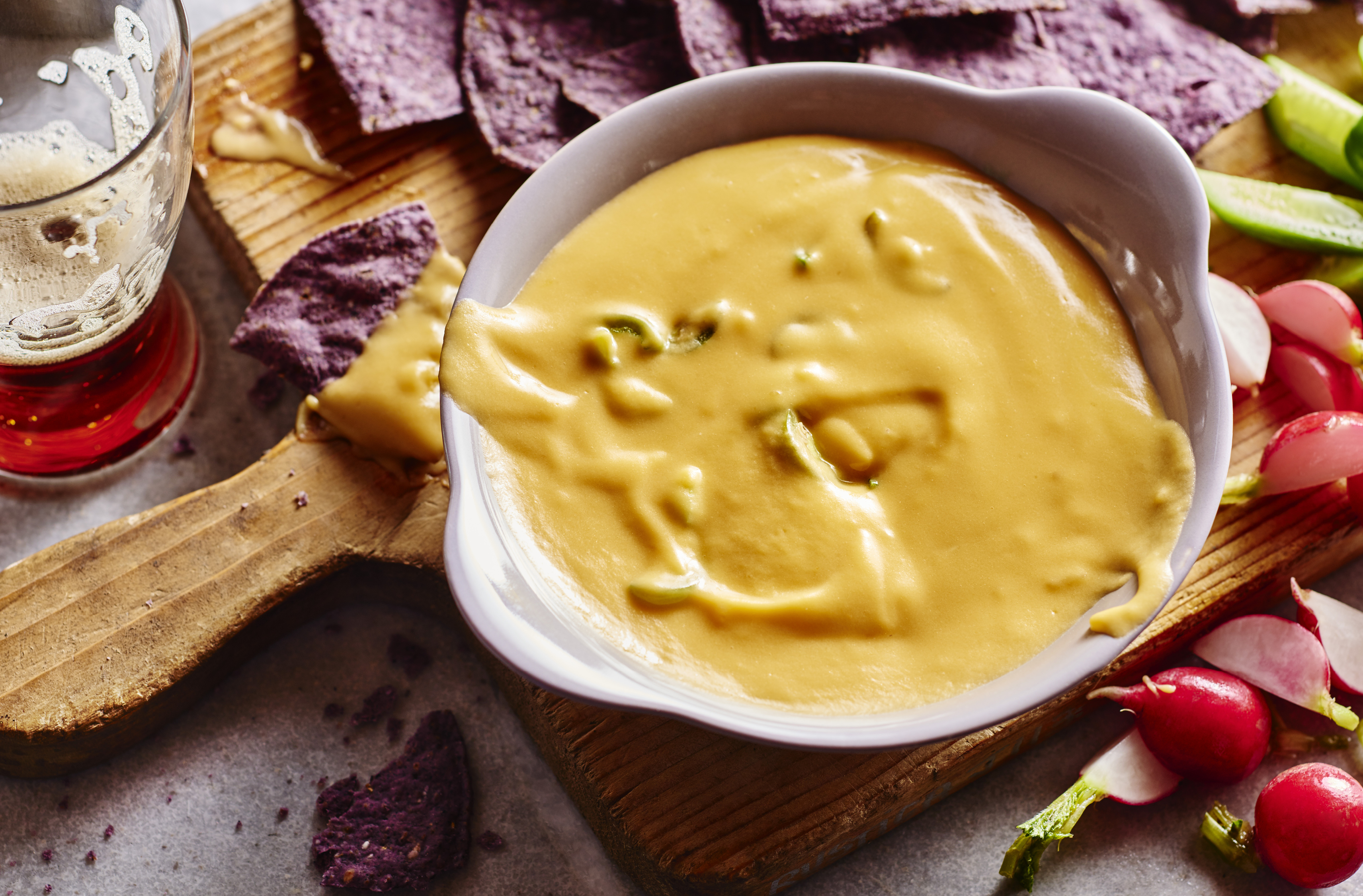 A bowl of lactose-free cheddar and beer dip with nachos
