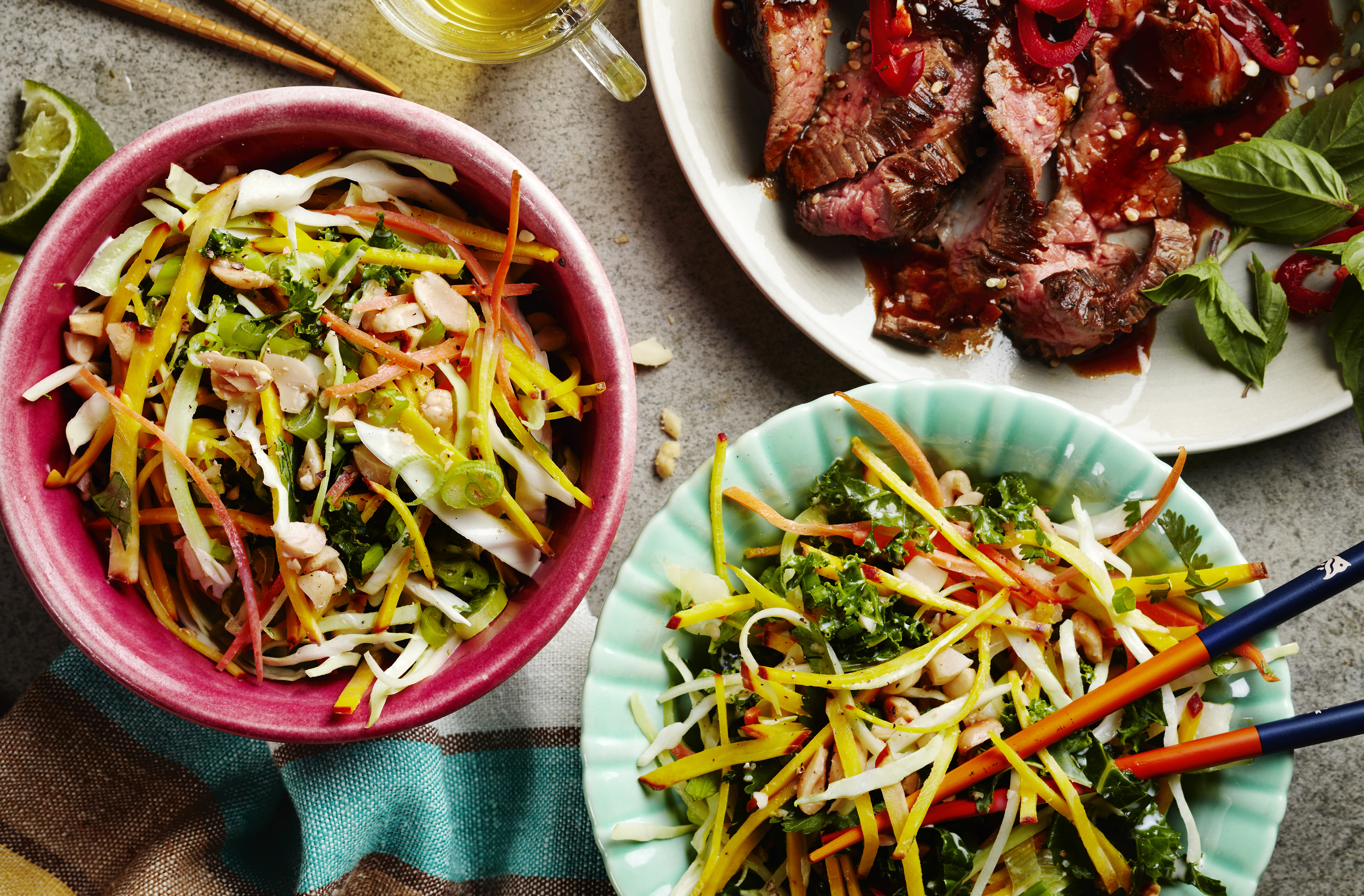 Two bowls of golden beet slaw with chopsticks and a platter of sliced beef
