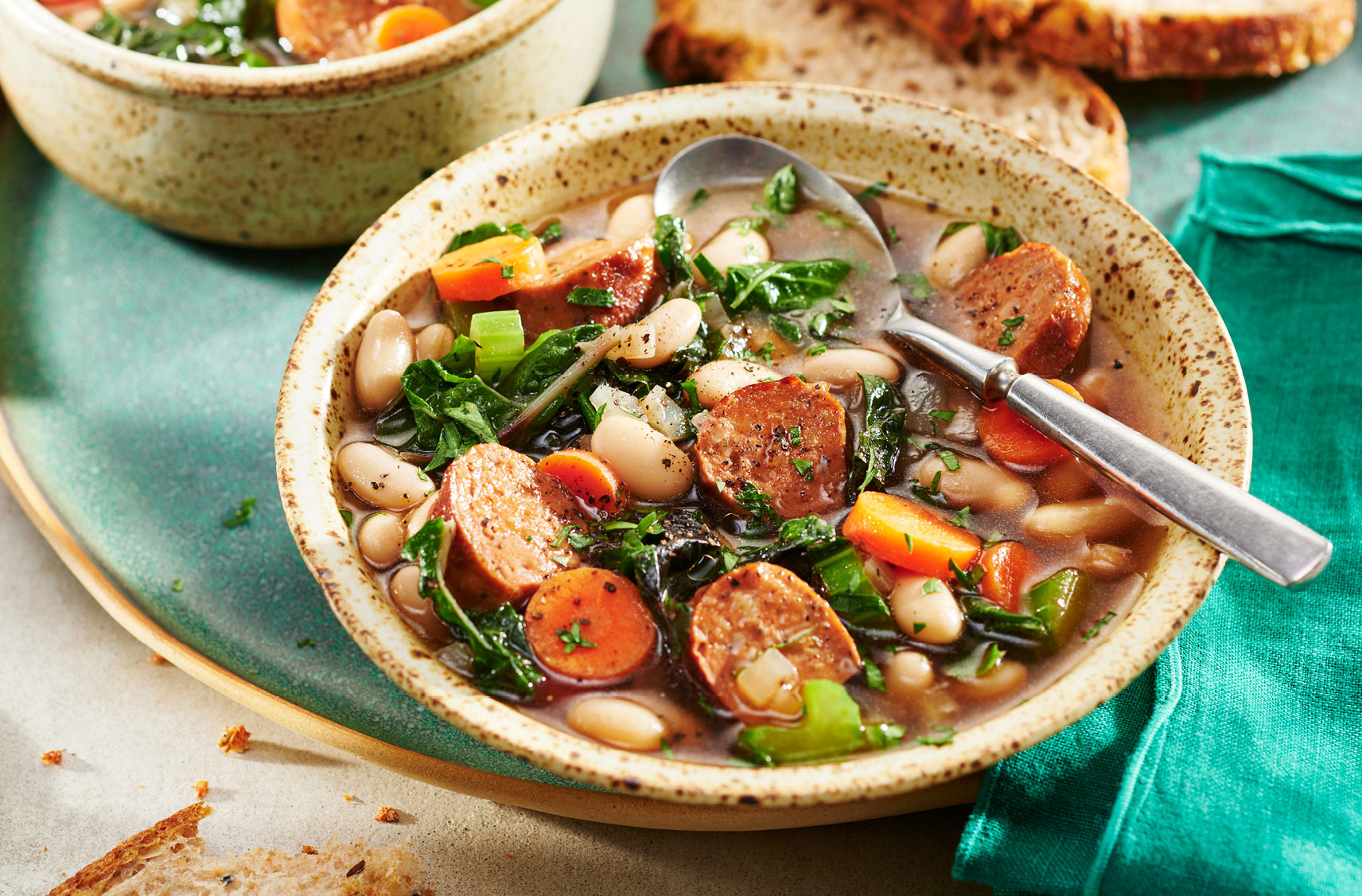 A bowl of Tuscan Soup with Plant-Based Italian Sausages and Plant-Based Beef-less Broth with Swiss chard, kidney beans and vegetables