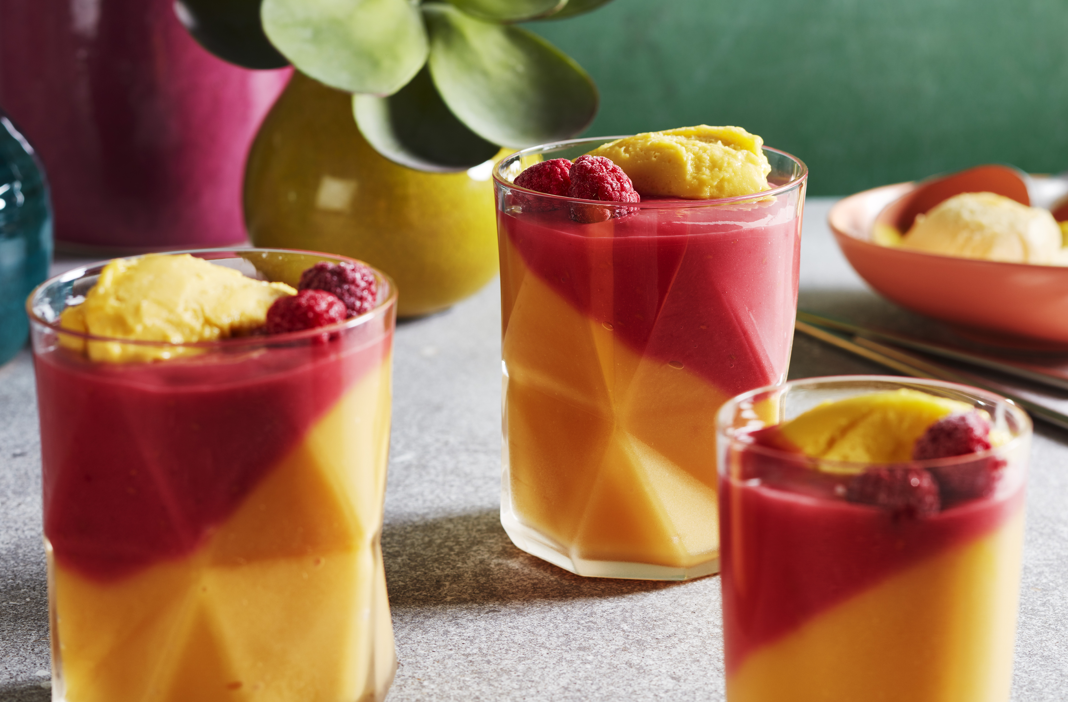 3 glasses of mango melba shake garnished with fresh raspberries