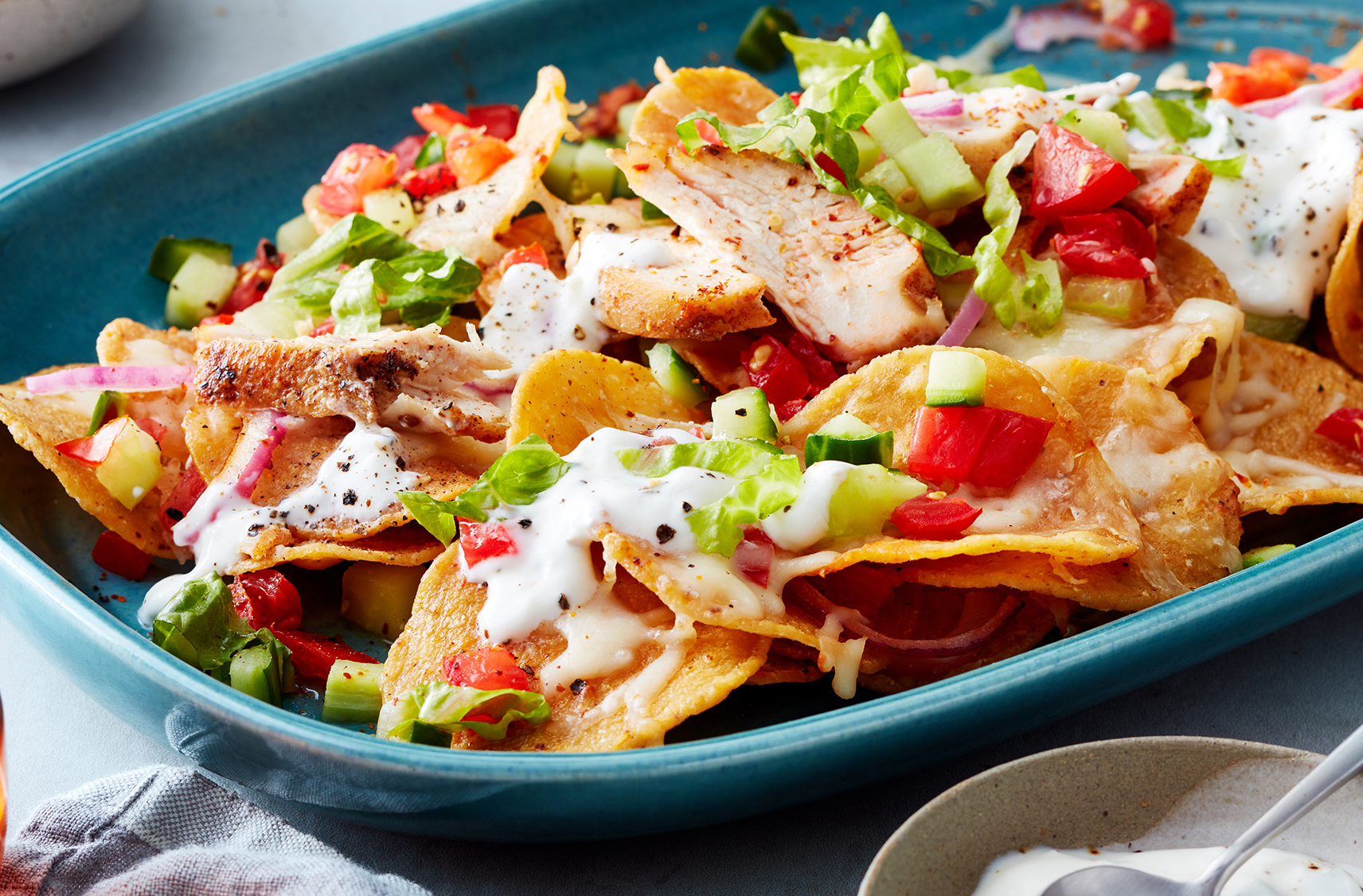 Seasoned chicken, diced veg, onion and a creamy drizzle top nacho chips