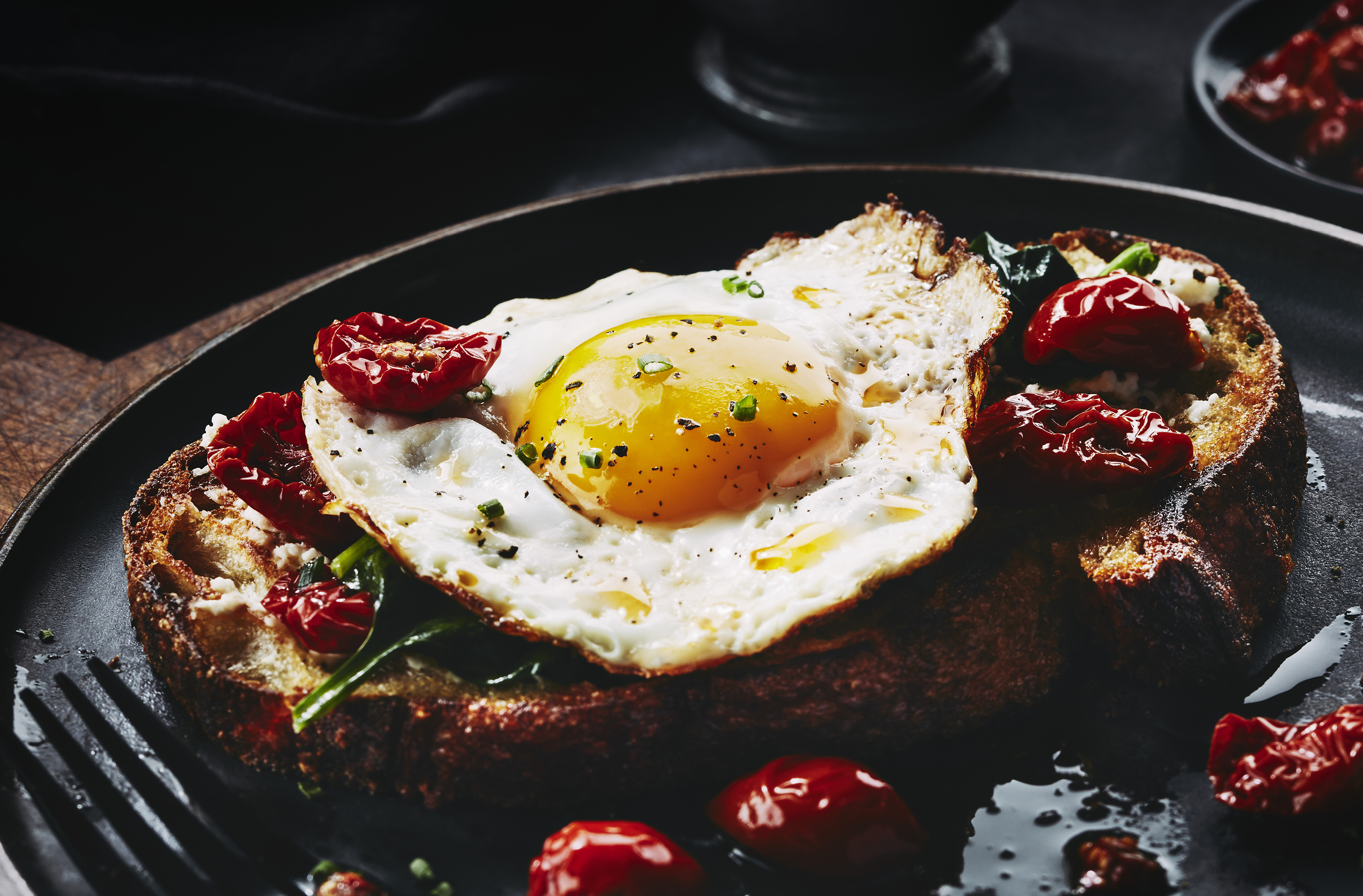 An open-faced egg sandwich with PC Black Label Roasted Cherry Tomatoes on a slice of toast.