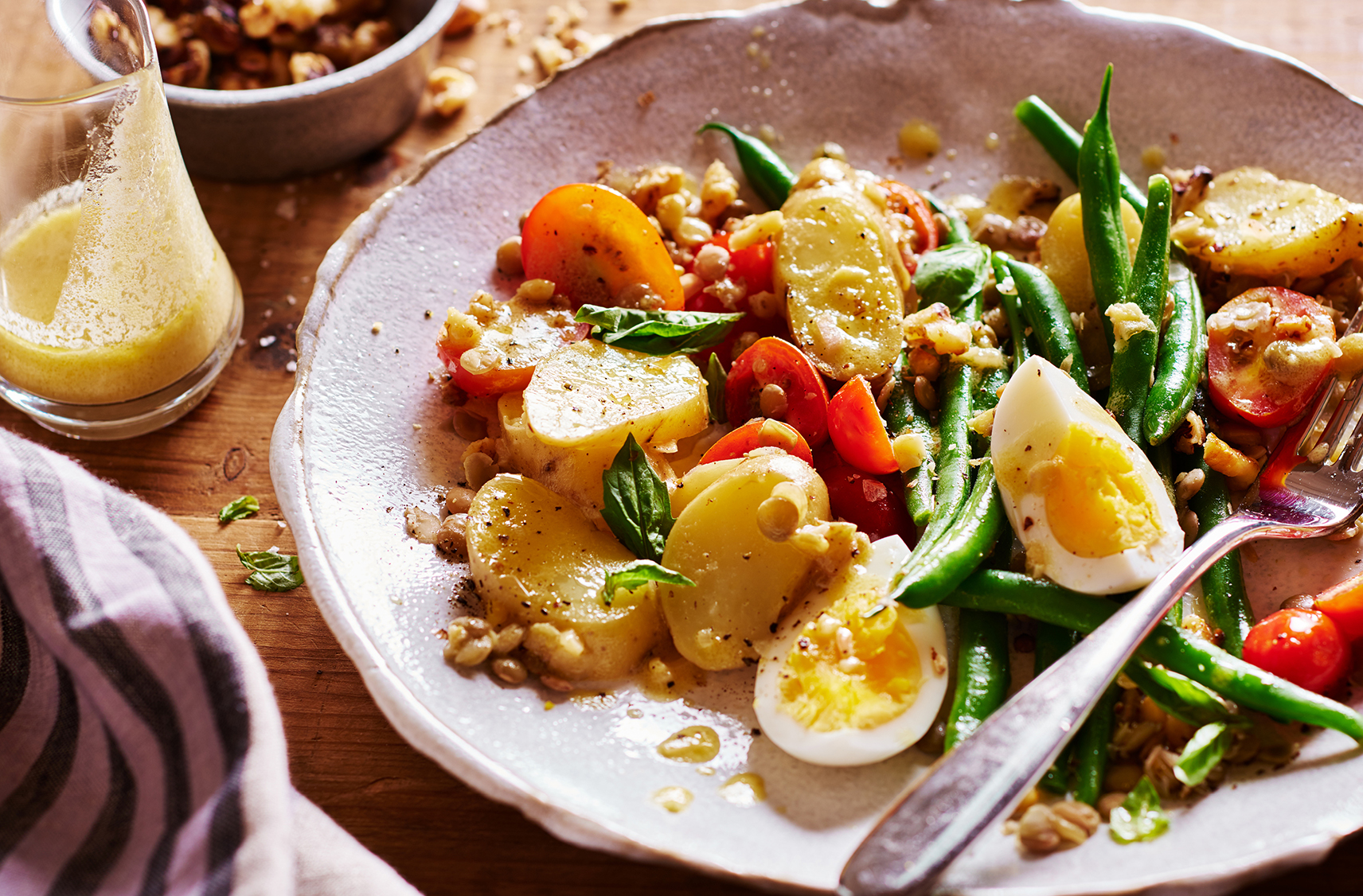 An arrangement of dark green beans, boiled eggs, lentils and potatoes 