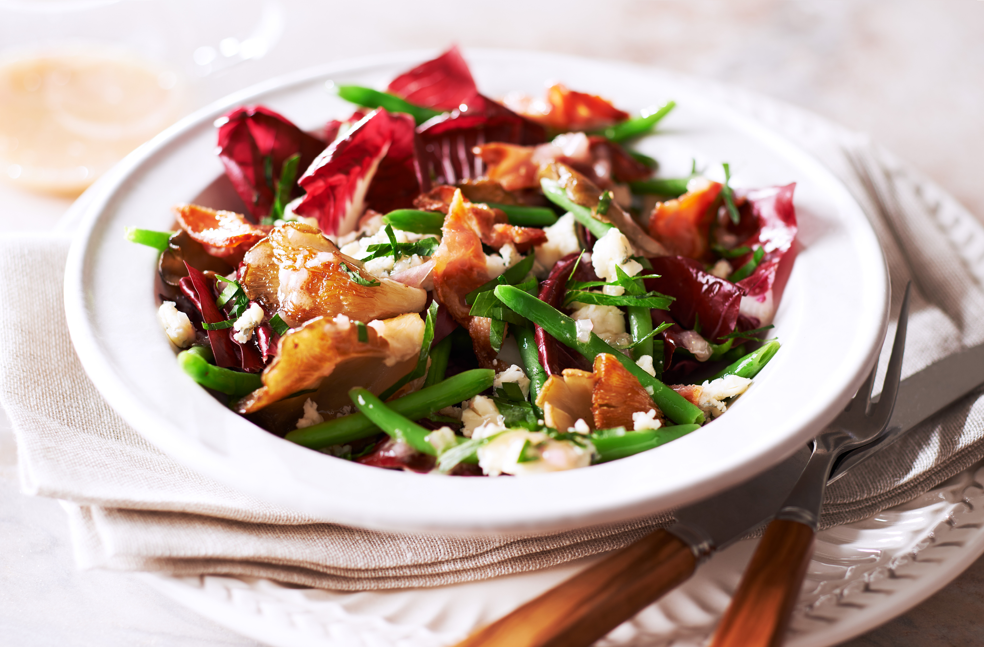 A bowl filled with a Treviso radicchio, green beans & oyster mushroom salad
