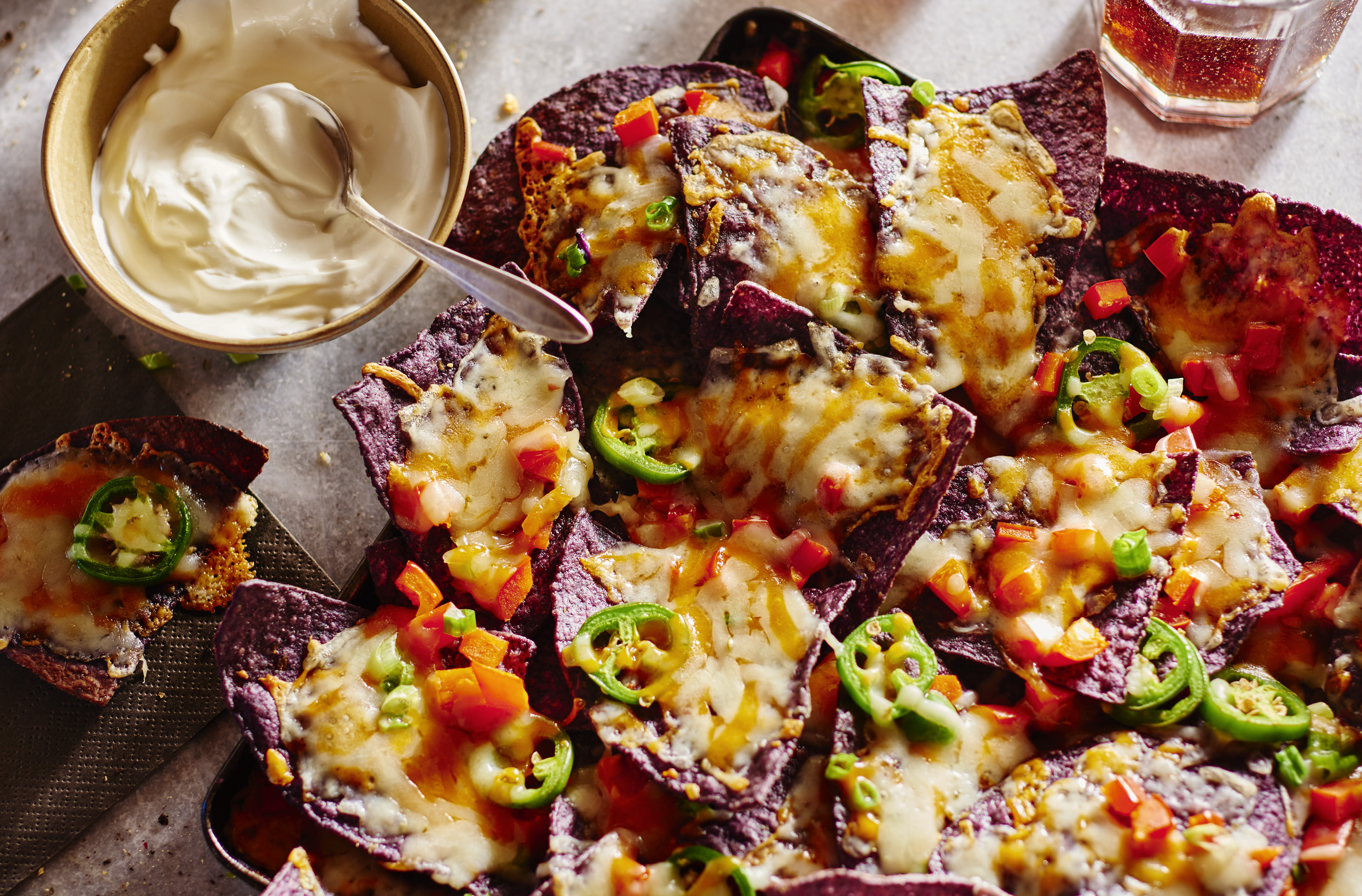 A platter of lactose free nachos and sour cream
