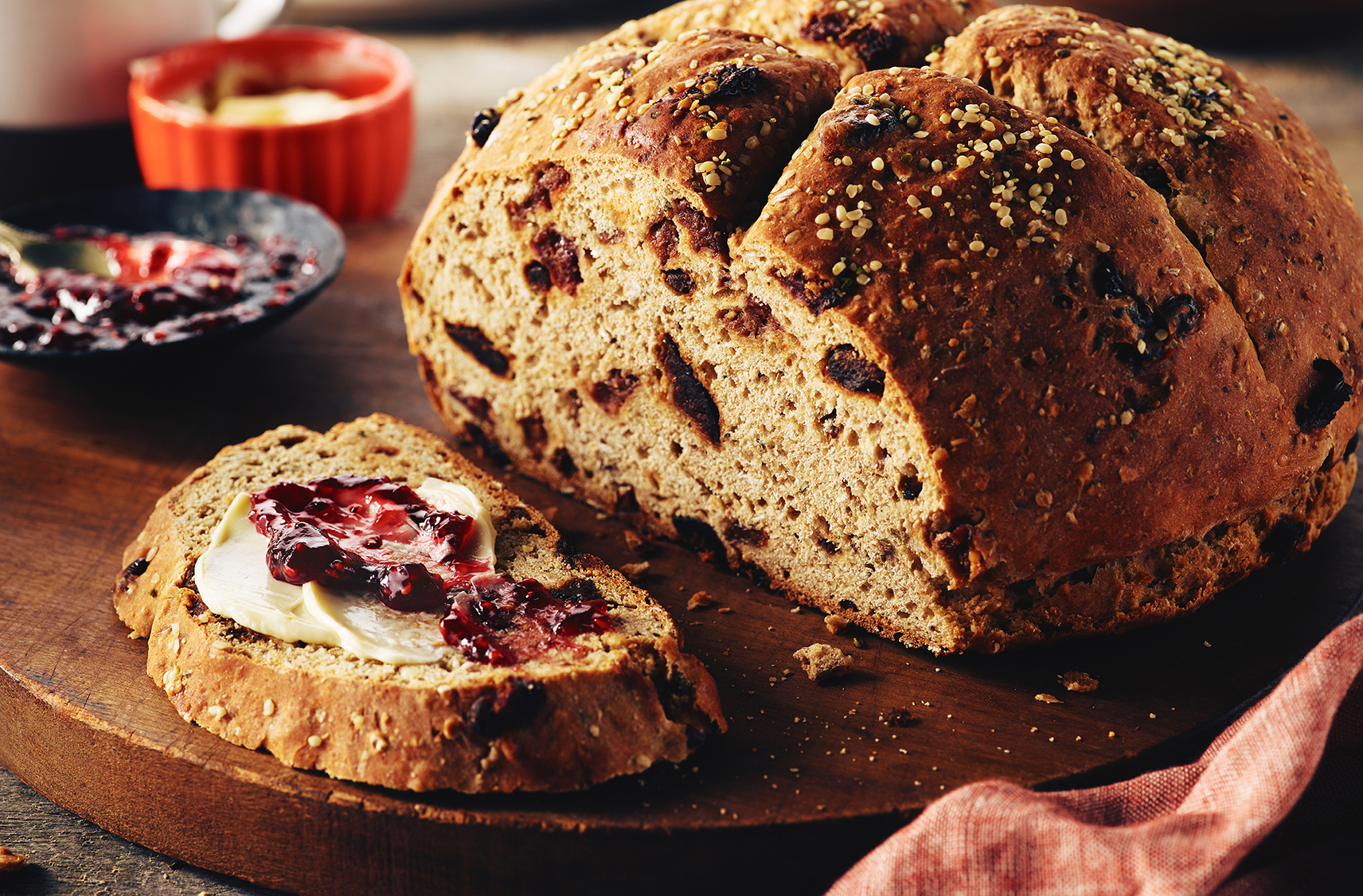 A slice of fig apricot soda bread, one slice smeared with butter and jam