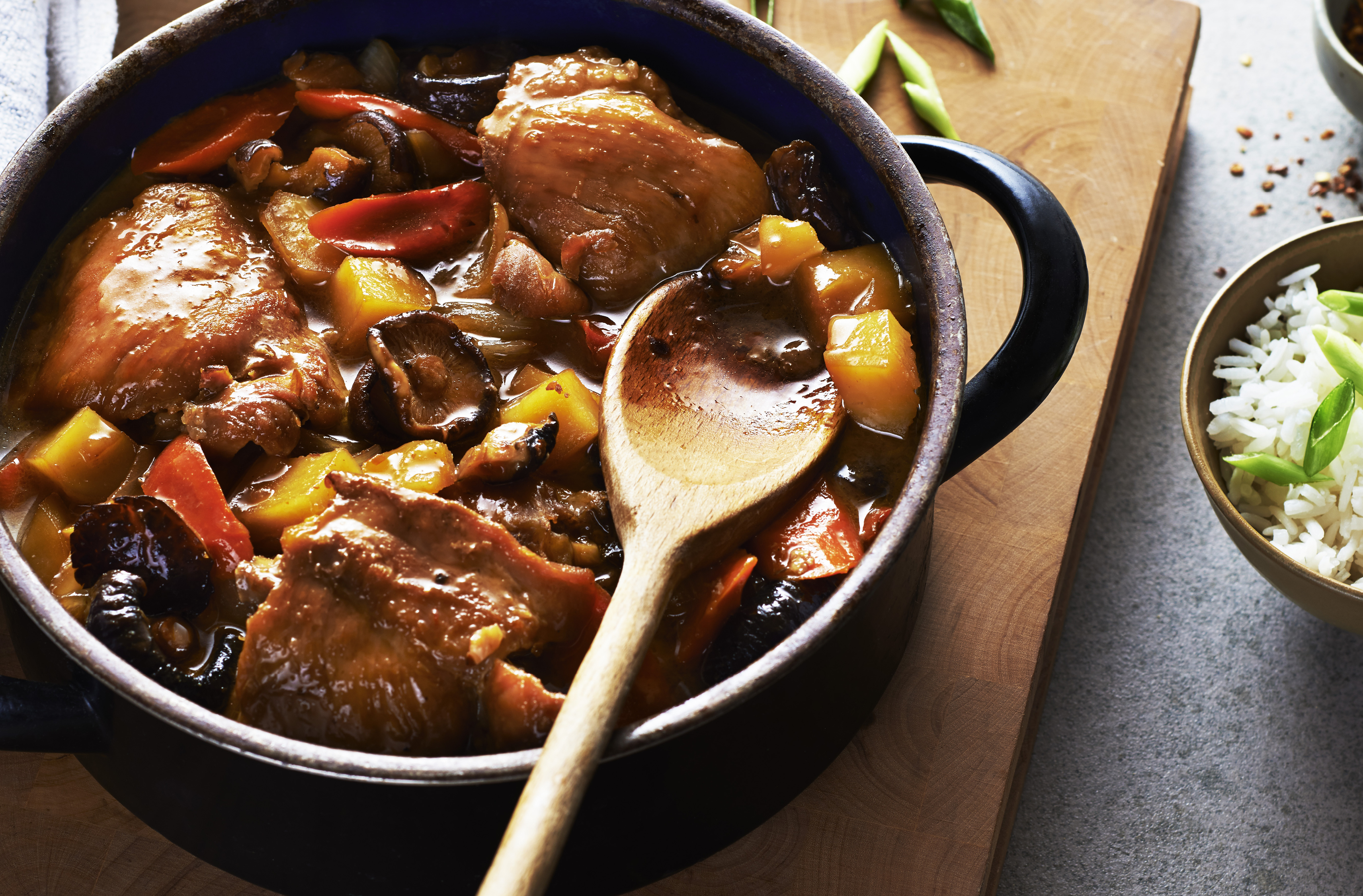 A spoon lifts out a chunk of meat out of a pot of stew