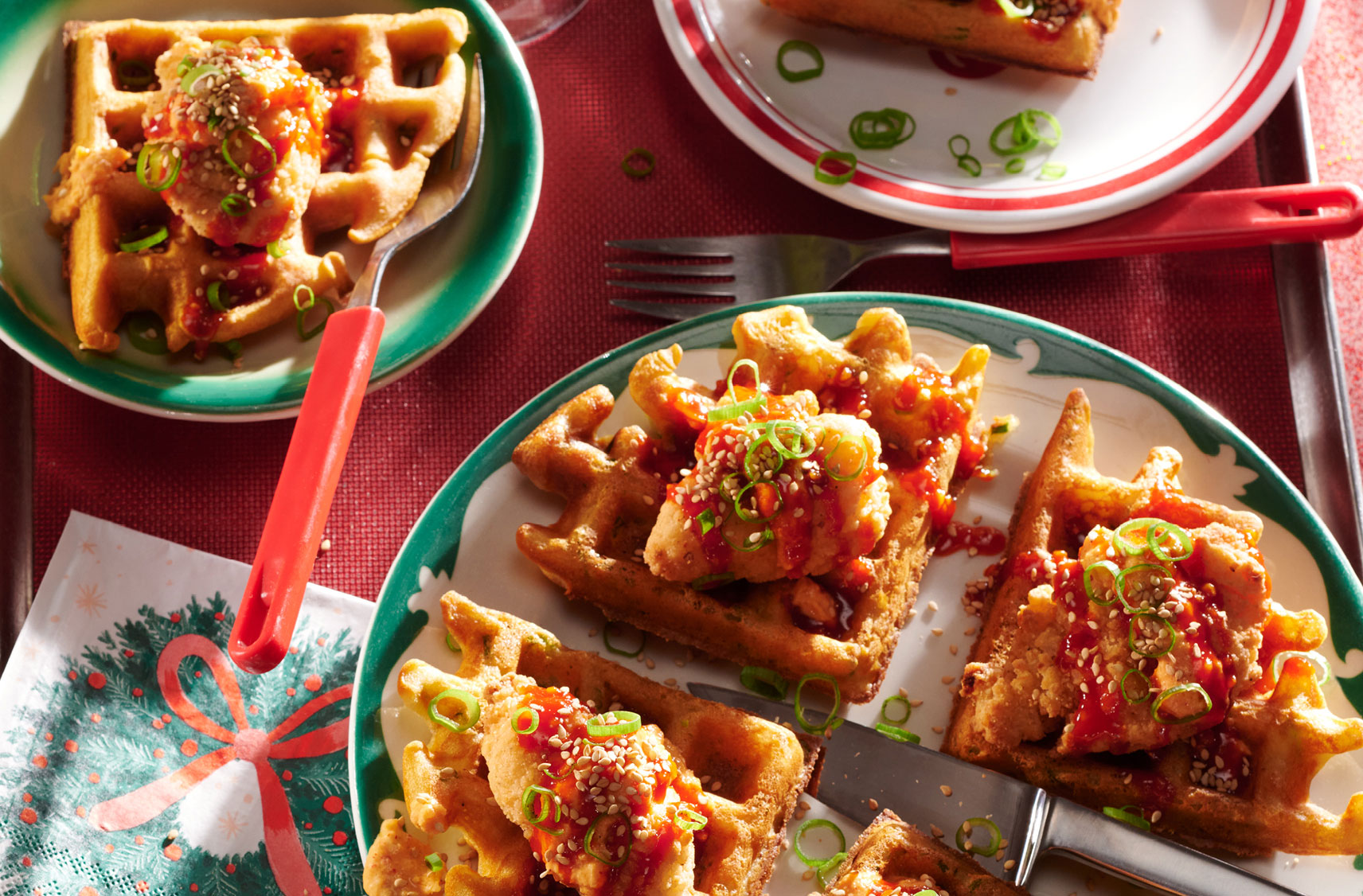 Des assiettes remplies de gaufres coupées en quatre et garnies de bacon, d'oignons et de tomates.