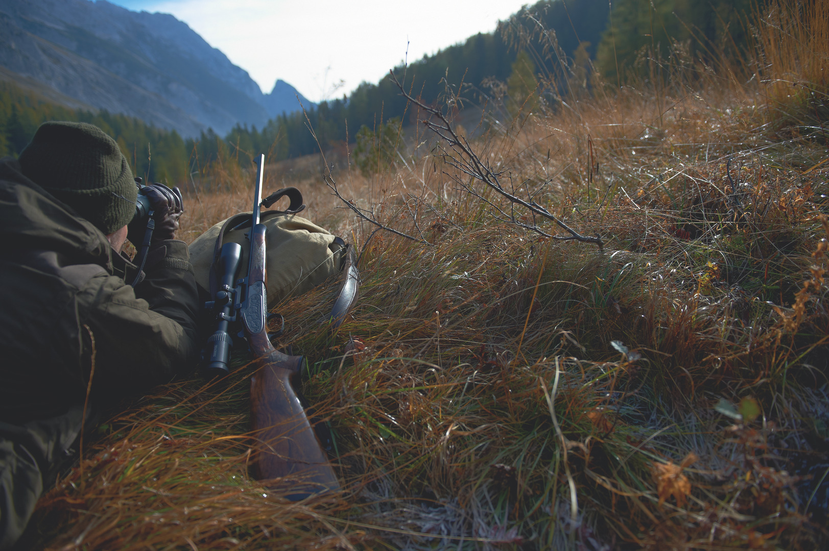 Hunter in the field with rifle and Z6i spotting with binocular