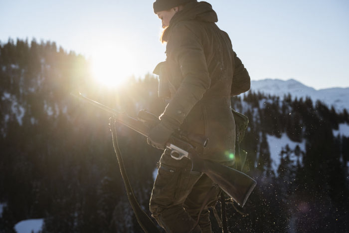 Huntress walking in the snow with the SWAROVSKI OPTIK Z8i 1,7-13,3x42 