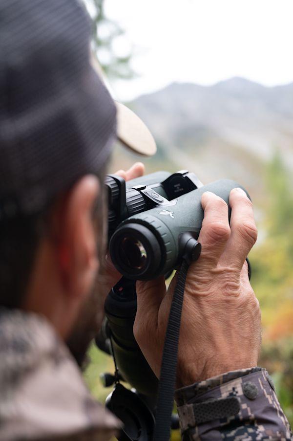 Hunting chamois with the SWAROVSKI OPTIK EL Range TA in the Swiss Alps, hunter holding the EL Range TA in his hands, ready to observe 