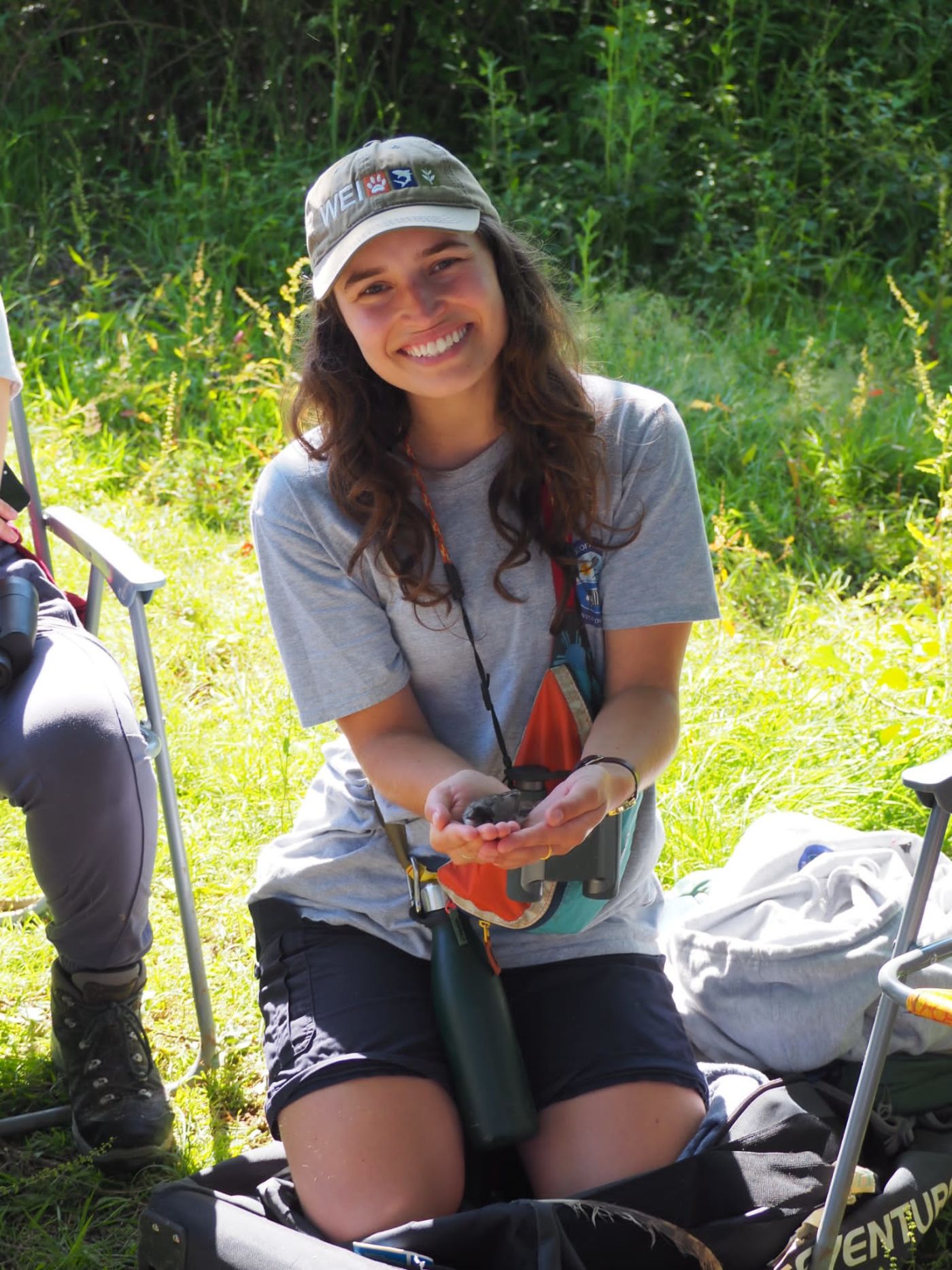 Bethany Newark with bird in her hands and SWAROVSKI OPTIK CL Pocket binoculars 