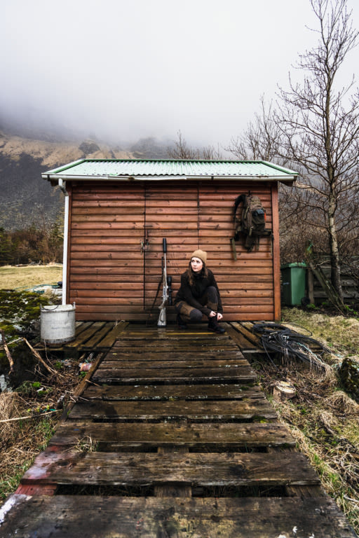 Iceland Hunters Alma sitting infront of a hut