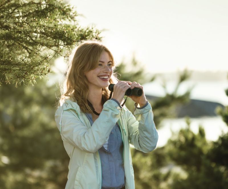 CL Companion 2017 woman with binoculars at lake ID 1037143
