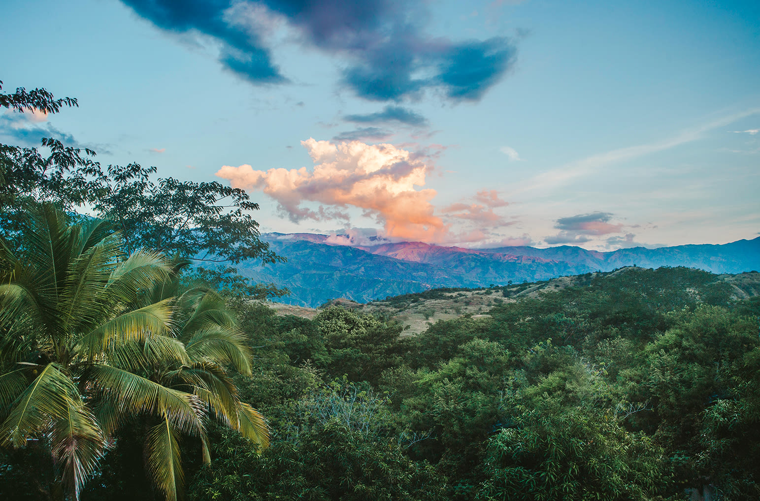 Sunset over the rolling lush green hills of the Antioquia landscape near Santa Fe, just outside the city of Medellin, Colombia