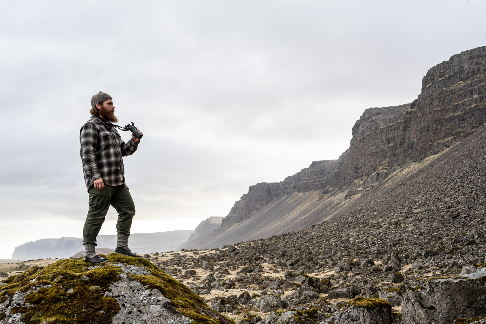 One with nature: the Iceland Hunters stalking with the NL Pure - Gunnar from hunting_iceland standing on a rock with the SWAROVSKI OPTIK NL Pure with FRP forehead rest rocky landscape 