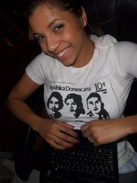 A smiling woman wears a Philadelphia Printworks tee printed with a vintage Republica Dominicana 10 centavos stamp design