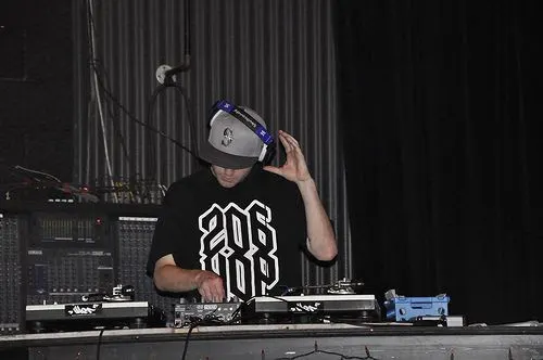 DJ Audeos behind the decks in headphones at Nectar Lounge in Seattle wearing a black 206-Hop tee and gray Seattle mariners cap at Winter Classic 2009