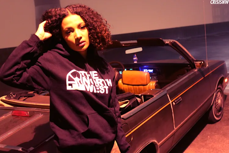 neko-jamilla-the-north-west-hoodie-leaning-on-convertible