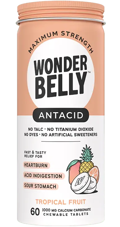 A Wonderbelly maximum strength antacid bottle labeled “Tropical Fruit,” listing fast and tasty relief for heartburn, acid indigestion, and sour stomach, with illustrated pineapple, mango, and orange on a peach‑colored label.