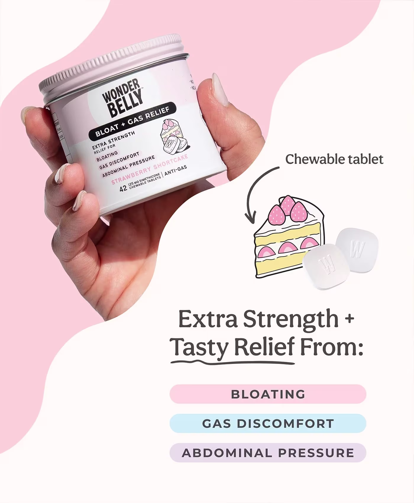 A hand holding a Wonderbelly strawberry shortcake bloat and gas relief jar, with illustrated cake and chewable tablets labeled “Chewable tablet,” plus text reading “Extra Strength + Tasty Relief From: Bloating, Gas Discomfort, Abdominal Pressure.”