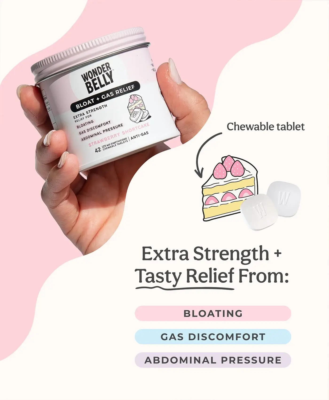 A hand holding a Wonderbelly strawberry shortcake bloat and gas relief jar, with illustrated cake and chewable tablets labeled “Chewable tablet,” plus text reading “Extra Strength + Tasty Relief From: Bloating, Gas Discomfort, Abdominal Pressure.”