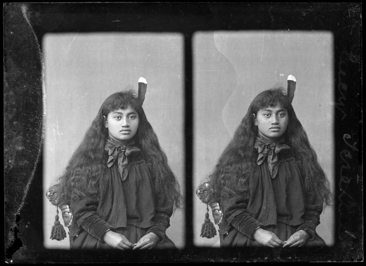 Stereoscopic image of a woman sitting for a portrait with a huia feather in her hair.