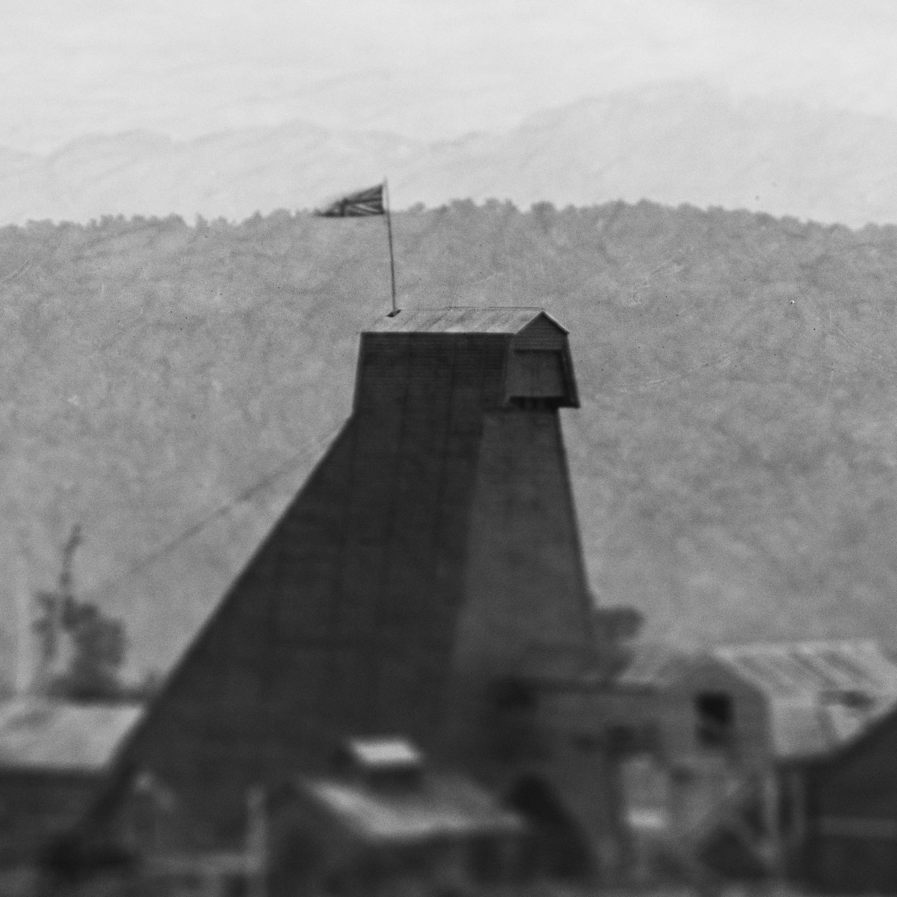 The top of the mine's south shaft headframe, with flag flying atop the large wooden structure. 