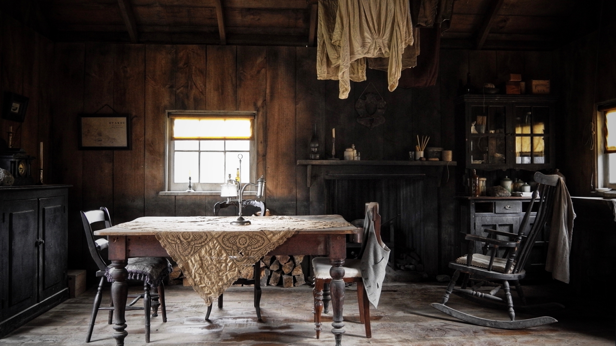 Interior view of an old house with wooden walls and furniture and decorated with antique objects from lat 1800s.