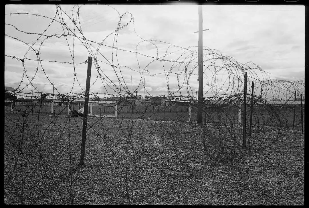 A rugby field fenced by barbed wire. 