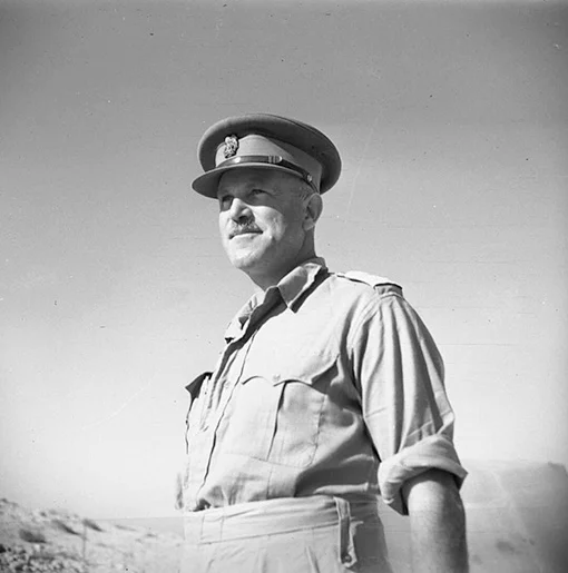 Black and white photo of a man with a moustache wearing a military uniform and cap.