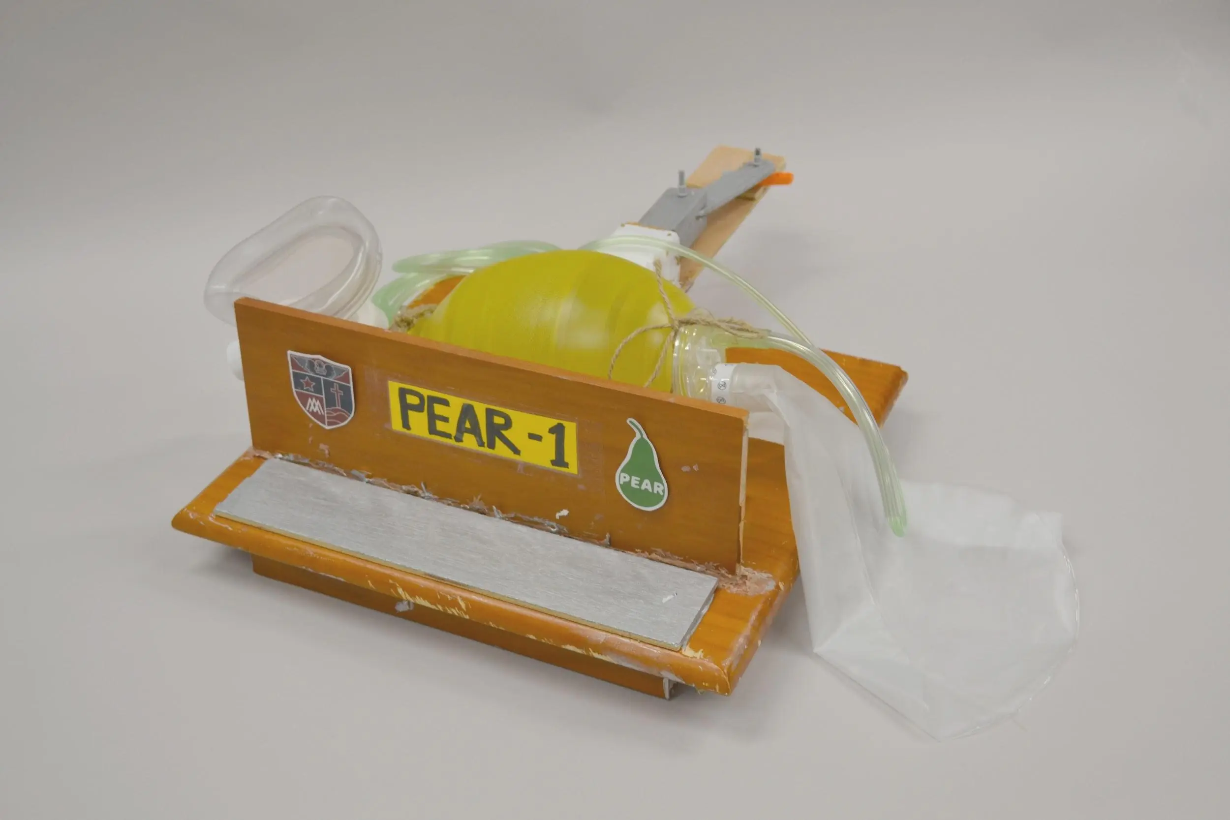 A homemade breathing apparatus with tape and glue visible along with a plastic yellow pump device.
