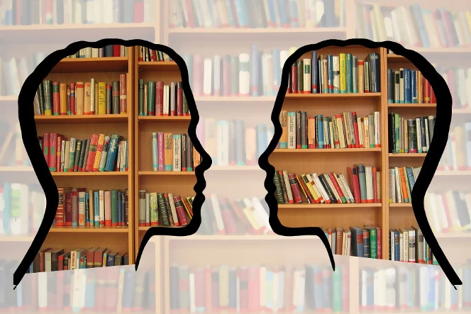 Silhouette of heads on a bookshelf.