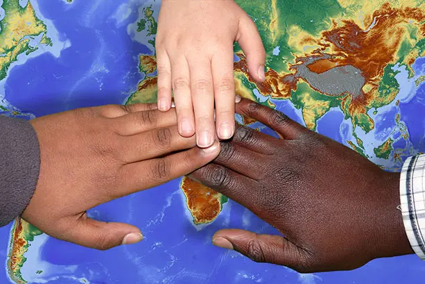 Colour photograph of 3 hands united above a satellite image of Earth.
