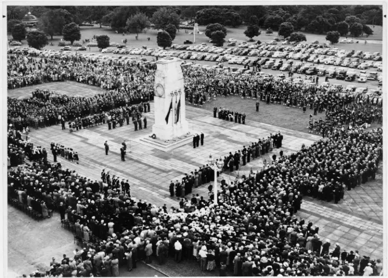 Anzac Day service, showing crowds gathered at a memorial.