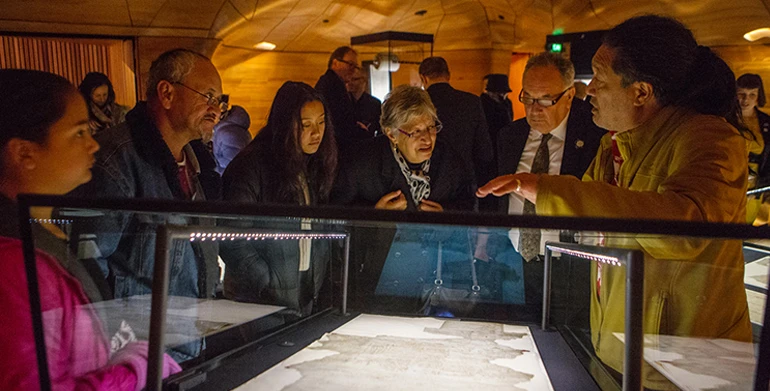 Visitors looking at Te Tiriti o Waitangi at the He Tohu exhibition opening.