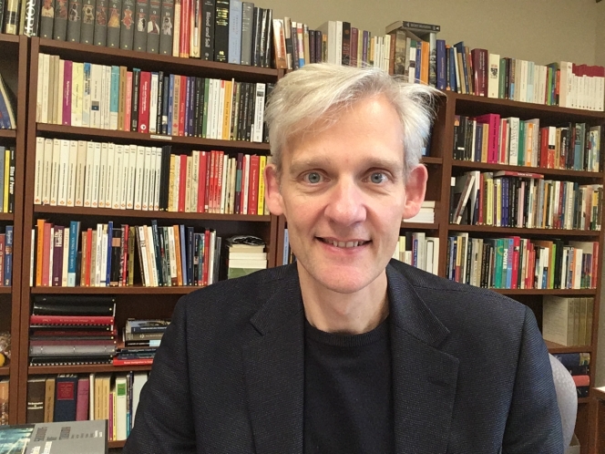 A portrait of Professor Alexander Freund in a study with bookshelf in background.