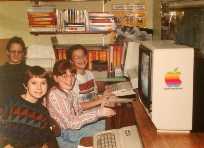 The author (pictured centre) at a Macintosh computer in her primary school. Photographer unknown.