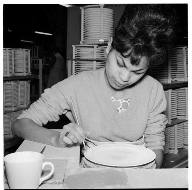 Worker applying a design to a dinner plate at Crown Lynn Potteries, Auckland, 1963, taken by Ans Westra (Reference: AWM-0522-06). No further use, including on websites, without permission of the copyright holder.