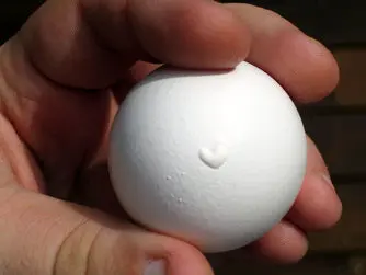 A white egg with a small heart on the outer centre.