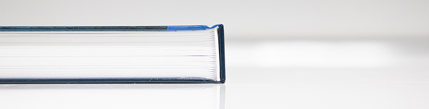 Top edge of a book on a white table.