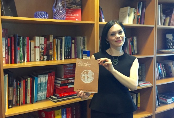 Tui Dewes at the embassy library with a copy of the Turnbull Library Record.