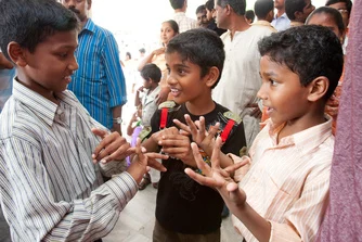 Three young boys signing following the historic Kerala Sign Language Bible dedication event in Kochi, India.