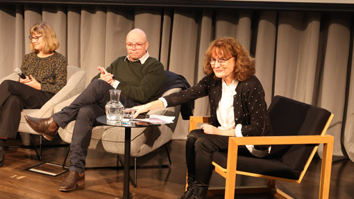 Kate De Goldi, seated with 4 other panellists, takes questions at a National Library panel event.