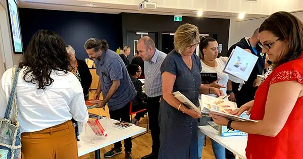 Photo of teachers looking at books on display at a National Library professional development event.