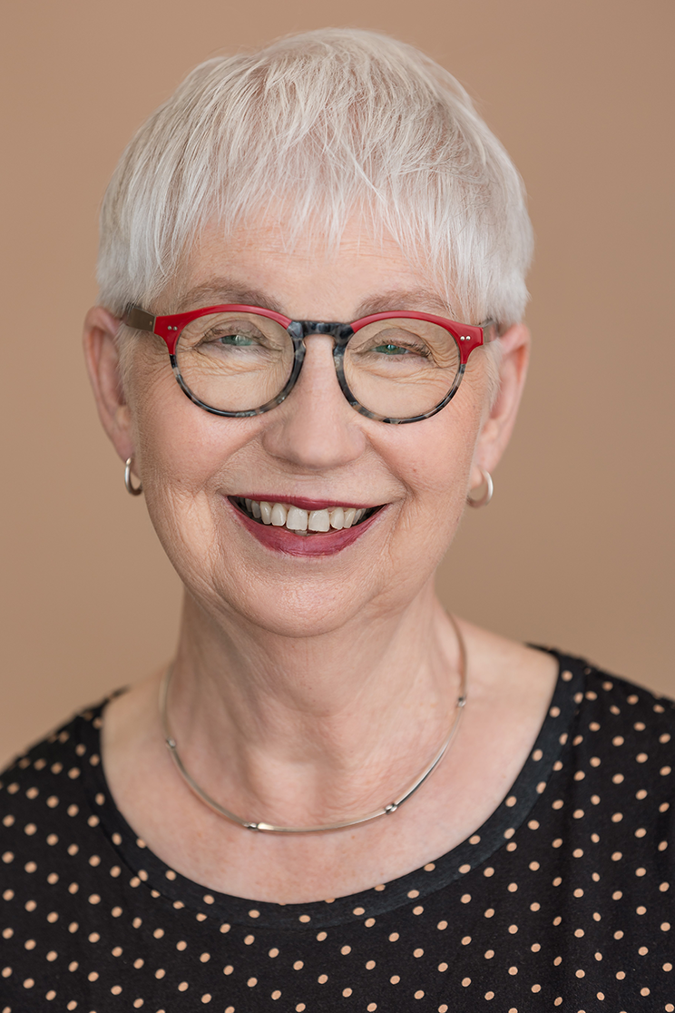 Headshot of a smiling woman wearing glasses.